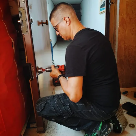 Tecnico al lavoro sulla serratura di una porta d’ingresso